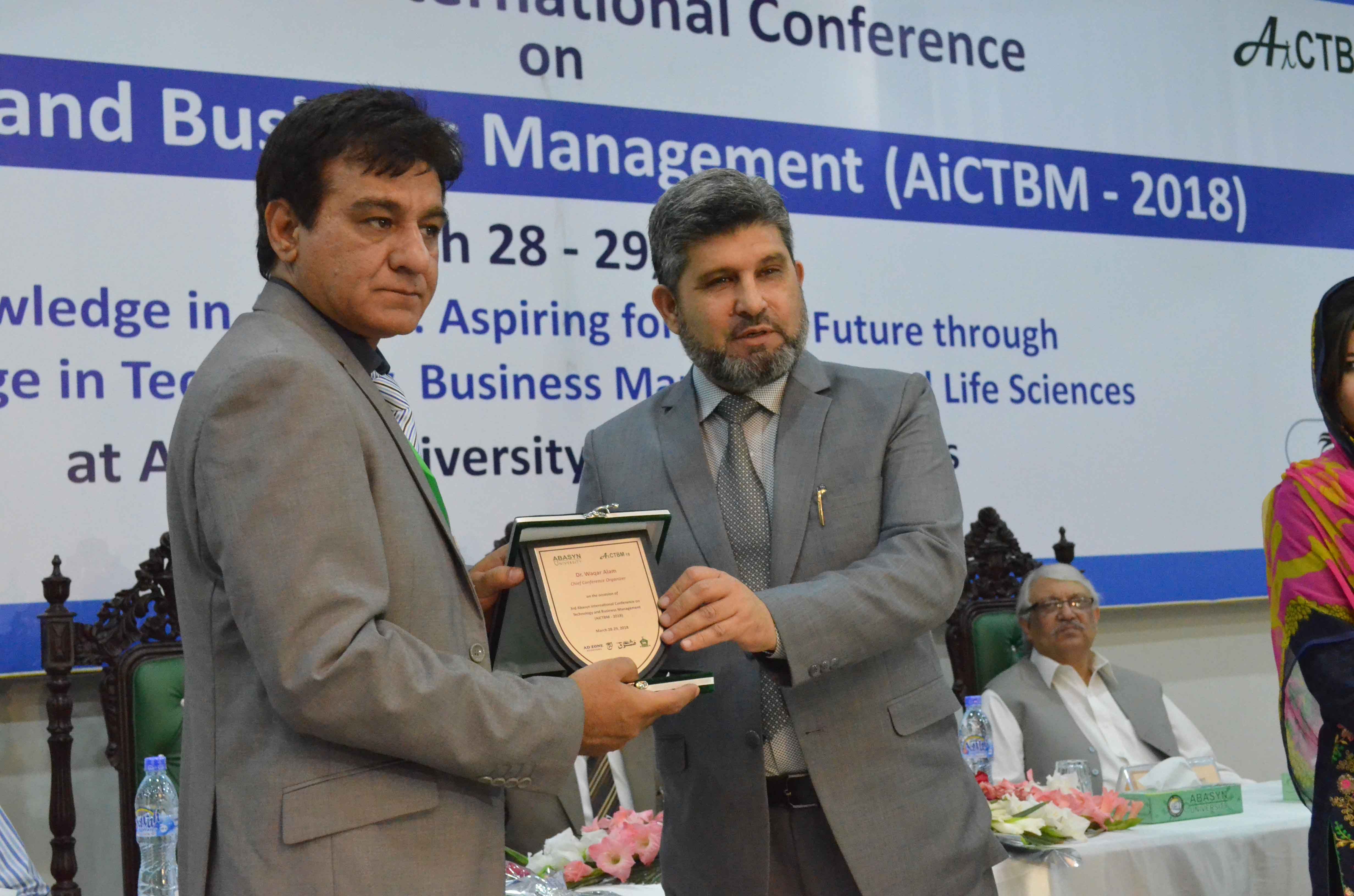 Dr. Syed Umar Farooq VC(Abasyn university) is presenting shield to Dr. Waqar Alam cheif organisr AiCTBM conference